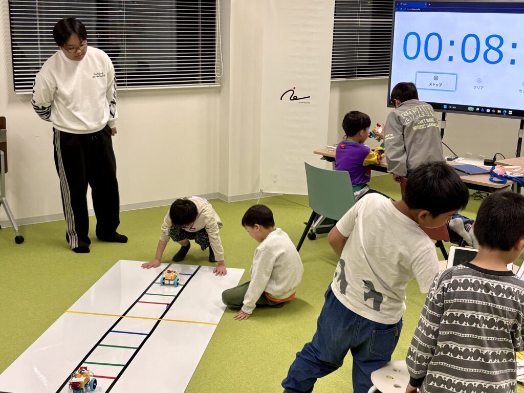 自分で作成したプログラムを使い、教室内でロボットを前後に動かしている様子